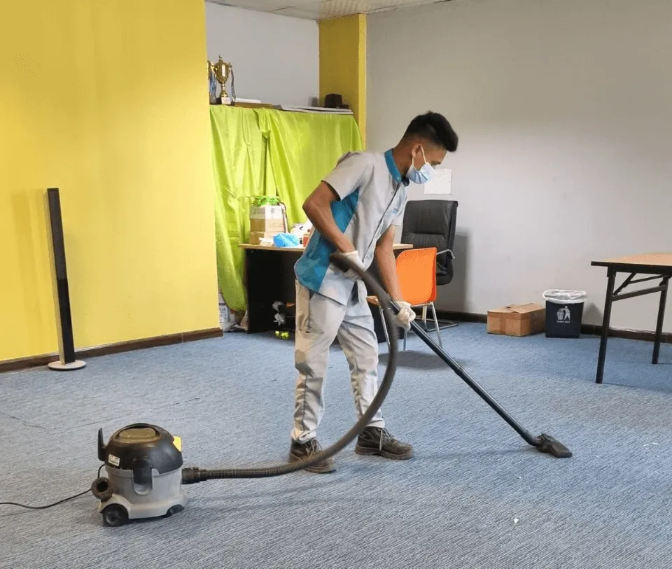 Professional cleaner vacuuming carpet during deep cleaning service in Abu Dhabi